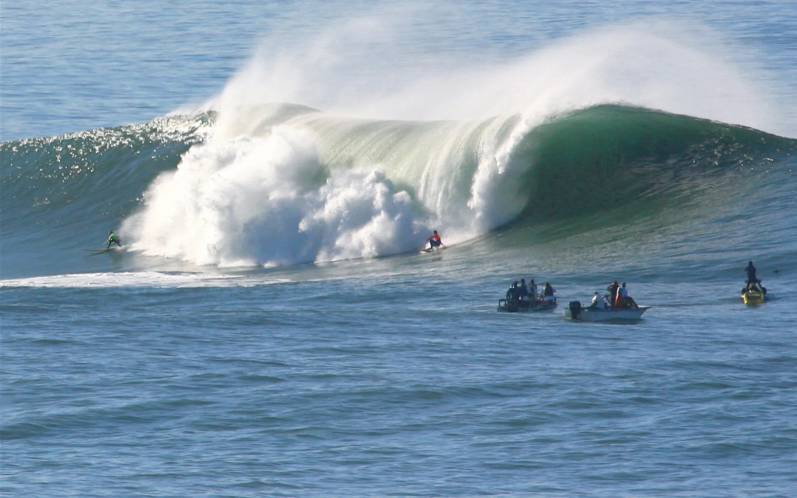 Surfers riding large waves at Mavericks, a famous big-wave surfing spot